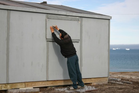Tommy's step-bother Jayko, who was one of the guides on this trip, boarding up the windows of Tommy's cabin. Notice the board he is carefully stepping on. Laced with nails sticking straight up, Tommy put them at each window to keep the polar bears from standing there and putting their paws through the glass.