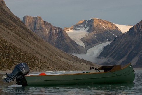 A portrait of the freighter canoe, boat of the north. They are the most trusted design of boat for the Inuit who use them for their lively hood. Sam, who was born on the land near Sam Ford Fiord, recalled that the glacier in the background used to be one larger glacier when he was young.
