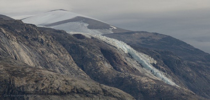 The sun pokes through the grey skies to catch a distant ribbon of ice.