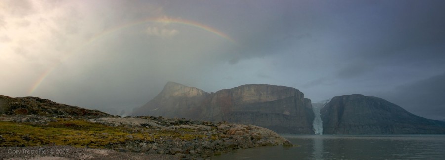 The sun is replaced by the rain as the last bit of light catches a nearby peak, and a rainbow tops off the day.